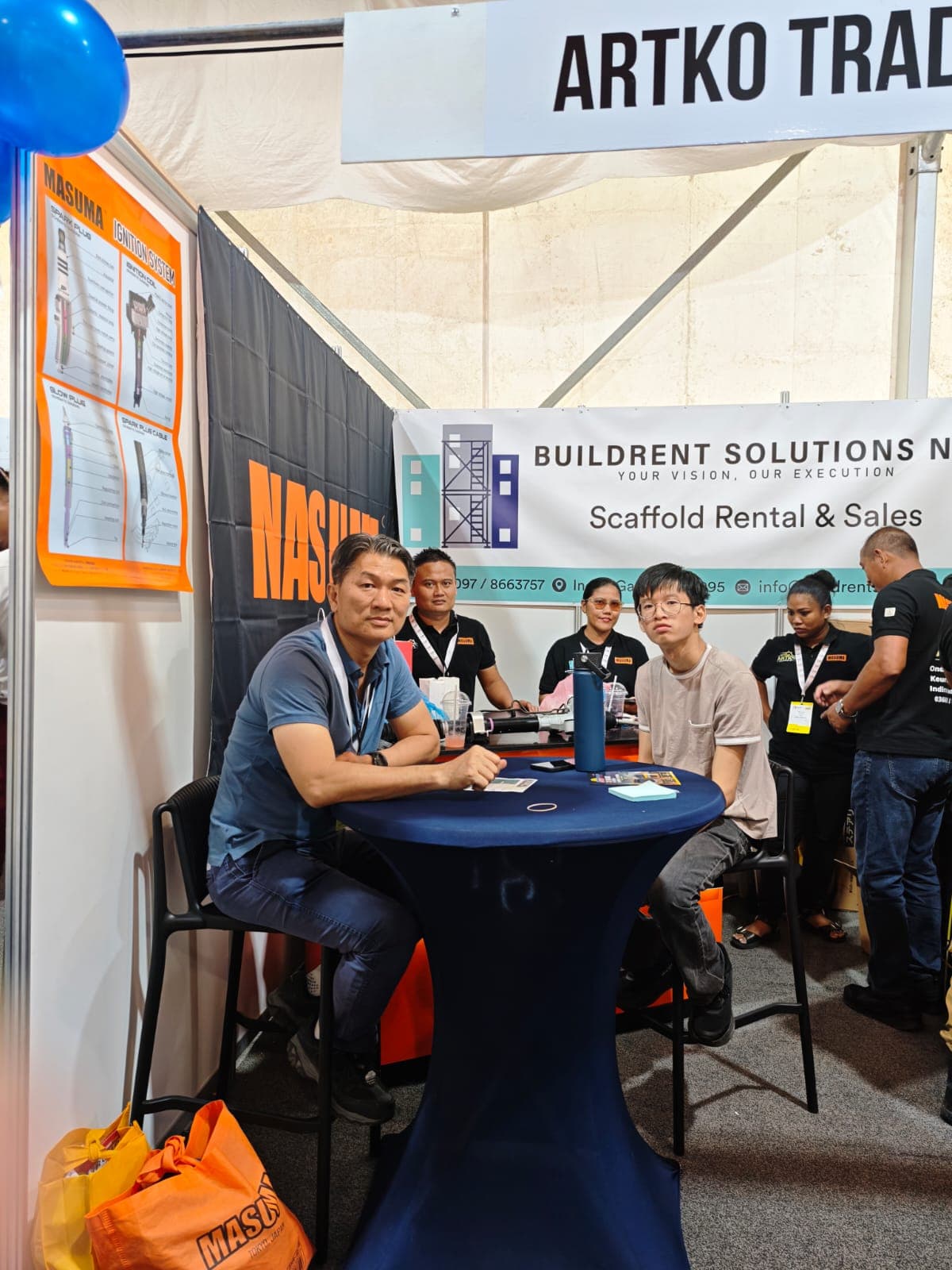 Attendees seated at booth